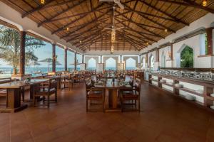 达累斯萨拉姆Aya Sophia Villa Garden Hotel的一间带桌椅的海景餐厅