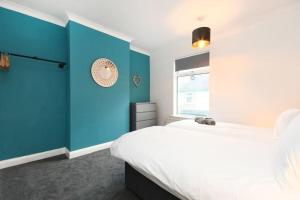 NewboldModern Town House in Chesterfield & The Peaks的蓝色和白色的卧室设有床和窗户