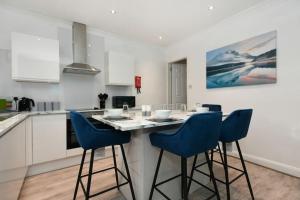 NewboldModern Town House in Chesterfield & The Peaks的厨房配有桌子和蓝色椅子