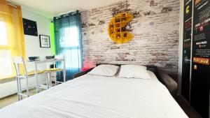 若奈克朗Appart Hotel Futuroscope 2 - Poitiers的一间卧室设有一张床和砖墙