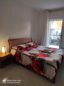 阿塞米尼Casa Giò的一间卧室,床上有红色的鲜花