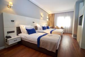 伊兹密尔Mitte Port Hotel Konak Izmir的酒店客房设有两张床和窗户。