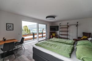 湖滨福煦Seeblick Homes的一间卧室配有一张床、一张书桌和一个大窗户
