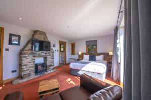 巴尔马哈橡树旅馆的一间卧室配有一张床和一个石头壁炉