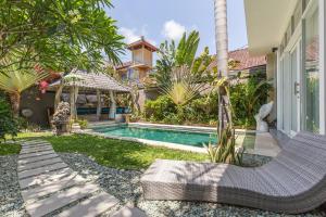 登巴萨Villa Maloa的一个带游泳池和房子的后院