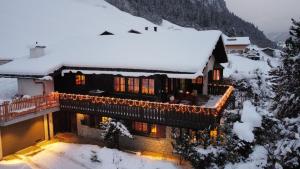克洛斯特斯多夫Chalet Alten的雪覆盖着的房屋,里面装着灯