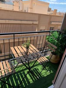 圣维森特德尔拉斯佩奇Apartamento Oasis Mediterráneo的阳台配有木桌和2种盆栽植物