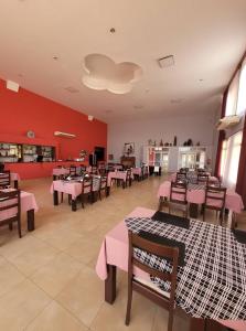 TartagalHotel Pórtico Norte的餐厅设有桌椅和粉红色的墙壁