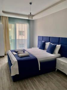 ÇiftlikköyPalmiye Gold的一间卧室配有蓝色的床和蓝色床头板