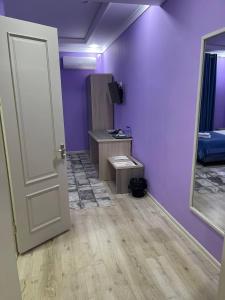 努库斯CITIZEN HOTEL的一间拥有紫色墙壁和白色门的房间