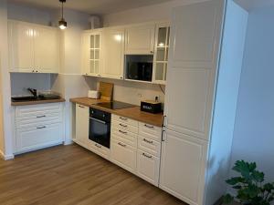 弗罗茨瓦夫The Botanic Corner Apartment的厨房配有白色橱柜和炉灶烤箱。
