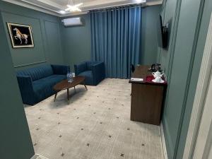 努库斯CITIZEN HOTEL的客厅配有蓝色的沙发和桌子