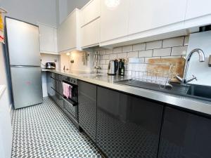 格拉斯哥1 Bed Character Filled Glasgow Apartment的厨房配有白色橱柜、水槽和冰箱。
