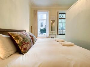 格拉斯哥1 Bed Character Filled Glasgow Apartment的卧室配有一张大白色床和窗户