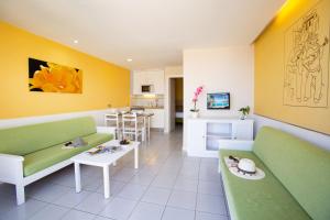 波多黎各里尔索尔酒店的客厅配有绿色和白色家具,厨房