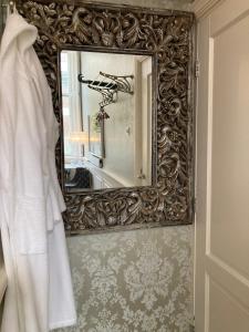 哈莱姆GuesthouseOne的浴室里一面镜子,墙上有白色的长袍