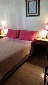 科洛尼亚-德尔萨克拉门托特里萨旅馆的一间卧室配有一张带红色枕头的床和一张桌子