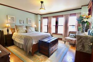 尼亚加拉瀑布The Marshall House的一间卧室配有一张床、一把椅子和窗户。