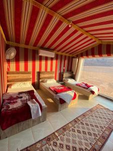 瓦迪拉姆Mountain Magic Camp Wadi Rum的一间卧室设有两张床和大窗户