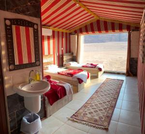 瓦迪拉姆Mountain Magic Camp Wadi Rum的客房内的浴室设有两张床和一个盥洗盆。