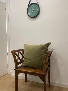 克卢什Relax Sintra Home - Near Lisbon的绿色枕头坐在木凳上,带时钟