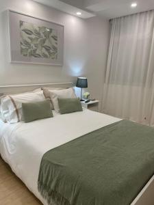 克卢什Relax Sintra Home - Near Lisbon的卧室配有一张带绿毯的大型白色床