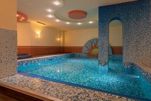 贝洛格拉奇Хотел "Скалите", Skalite Hotel的蓝色瓷砖的房间里的一个大型游泳池