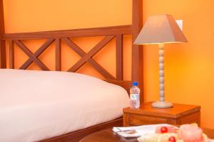 AzizacoueCasa Del Papa Resort & SPA的一间卧室配有一张床和一张带台灯的桌子