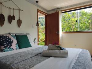 阿布拉奥Suites casa do indio jungle, a melhor vista da floresta的一间卧室设有一张大床和大窗户