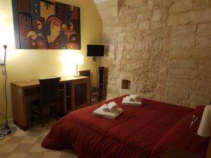 莱切B&B Residenza Pizziniaco的一间卧室配有红色的床和毛巾