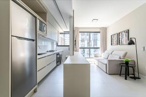 弗洛里亚诺波利斯WI-FI 300MB | 400m da UFSC #CARV01的厨房以及带冰箱和沙发的客厅。