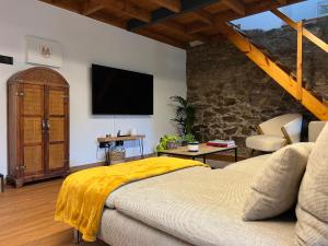 拉科鲁尼亚Rural Lambre by Miramar Stays的卧室配有一张床,墙上配有电视。