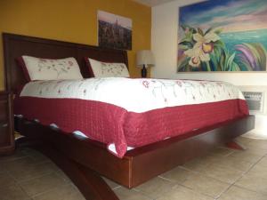 那不勒斯那不勒斯格莱兹汽车旅馆 的一间卧室配有一张大床,配有红色和白色的棉被