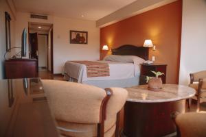 萨尔塔卡萨利尔酒店的酒店客房带一张床、一张桌子和椅子