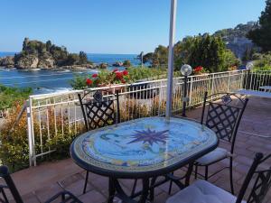陶尔米纳Taormina Isola Bella Apartment - Taormina Holidays的海景露台配有桌椅