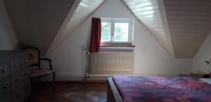 施泰因Ferienwohnung Stein am Rhein Nahe Bahnhof und Rhein的阁楼卧室设有床和窗户。