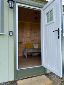 沃里克Beautiful 1 Bed Shepherd Hut in Warwickshire的通往带沙发的庭院的开放式门