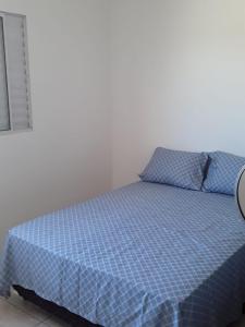 伊塔尼亚恩casa de praia campos的卧室内的一张床铺,配有蓝色棉被