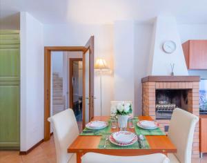 Presciano[Siena] Appartamento con splendido terrazzo的一间带桌椅和壁炉的用餐室