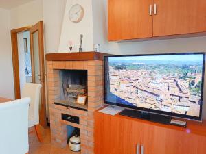 Presciano[Siena] Appartamento con splendido terrazzo的客厅设有砖砌壁炉,配有电视