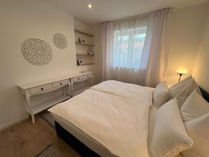 梅尔克万德尔威格度假屋的卧室配有白色的床和窗户。