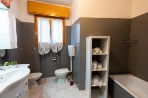 塞斯托拉Loft in Centro con Camino - Sestola的浴室配有卫生间、浴缸和水槽。
