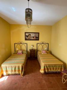 扎哈拉Mirador del farmacéutico的黄色墙壁客房的两张床