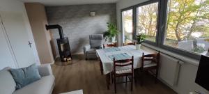 Echternacherbrückgemütliche Wohnung mit Kamin - Sunny Hill Holiday Home的客厅配有桌椅和壁炉
