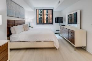 华盛顿Global Luxury Suites at Capitol Hill的白色卧室设有一张大床和一个梳妆台