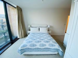 伦敦Spacious two Bedroom Apartment in Balham的一间卧室设有一张床和一个大窗户