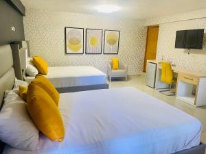 El Paso Hotel的酒店客房 - 带两张带黄色枕头的床