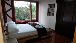 UlloaApto/cabaña naranja的一间卧室设有一张床和一个窗口