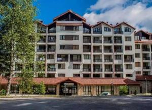 波罗维茨Apartment E23 Borovets Gardens的一座带停车场的大型公寓楼