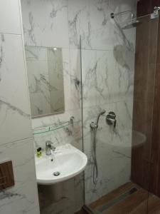 波罗维茨Apartment E23 Borovets Gardens的带淋浴和盥洗盆的白色浴室